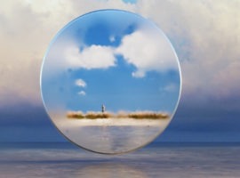 Image of a person through a telescope lens on a distant beach, representing inflation and supply chain issues affecting all parts of the world.