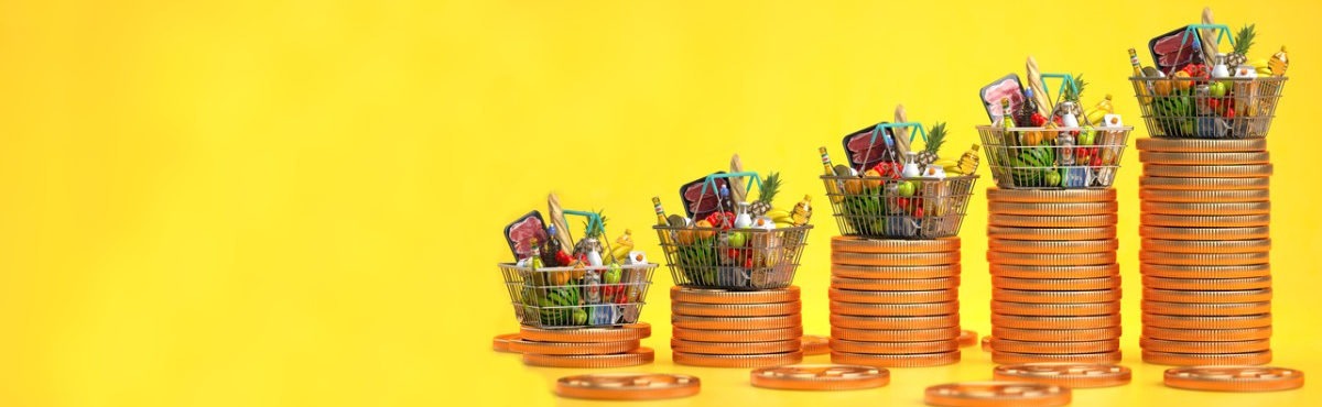 Basket of groceries stacked on coins, each stack of coins growing larger, but the basket size remaining the same, representing thanksgiving inflation and supply chain issues.