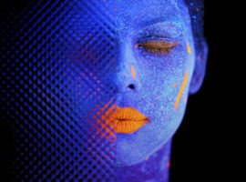 head of a blue woman with orange lips and closed eyes, representing attention economy.