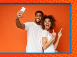 A couple looking up at a cellular device and smiling, representing a B2B commerce strategy for digital natives.